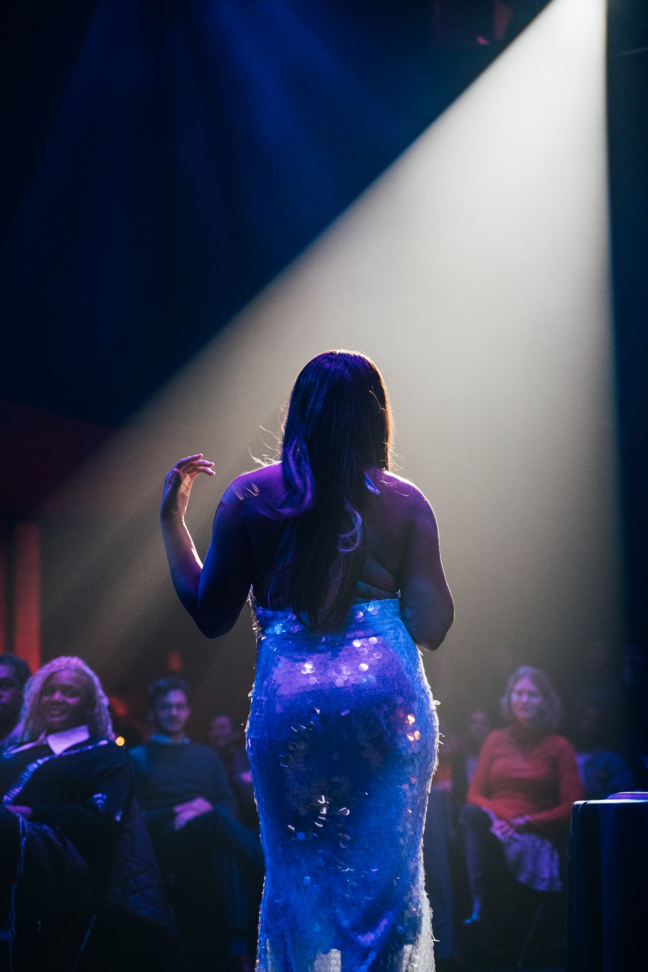 Spinning dress from behind, audience visible
